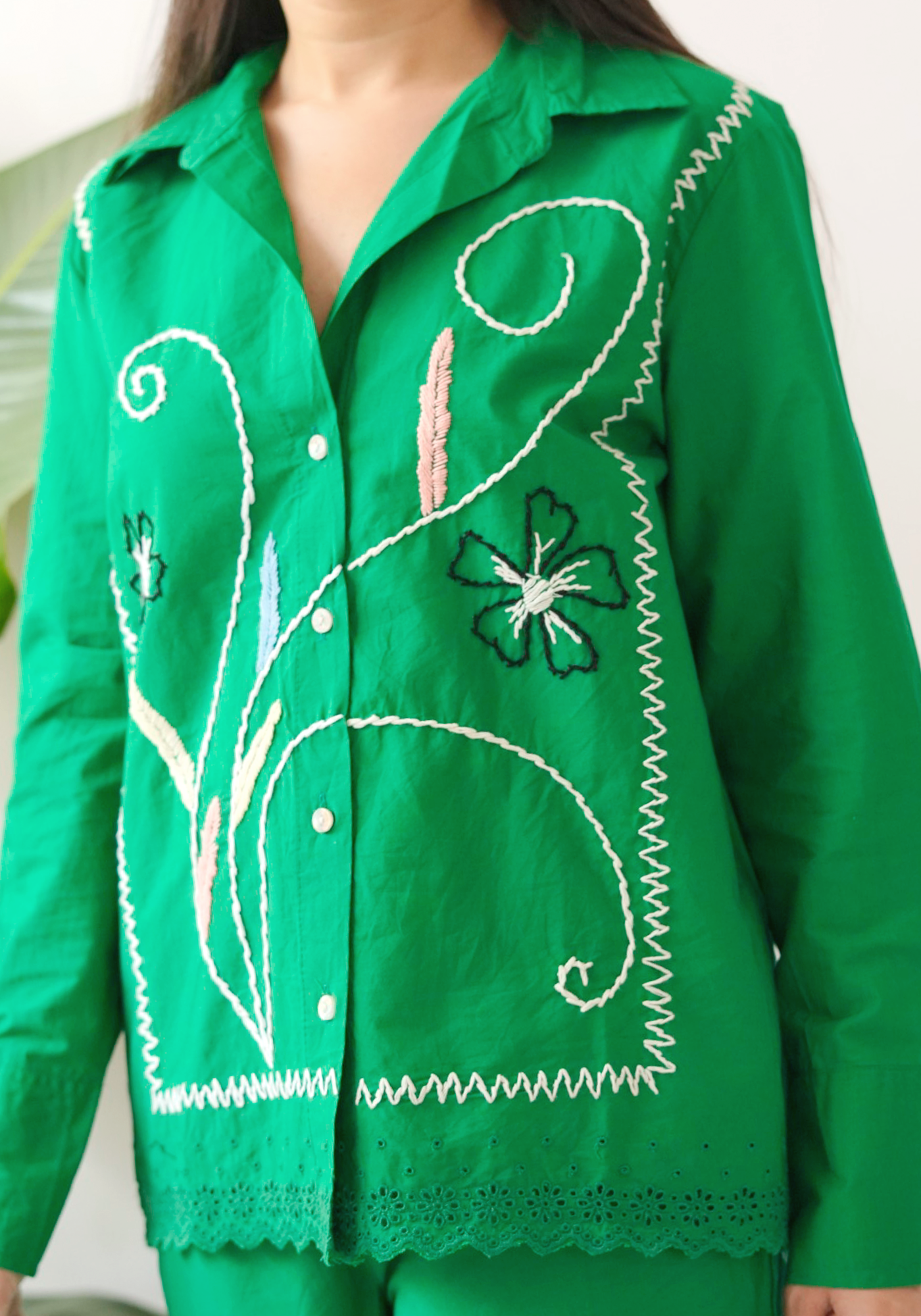 Green embroidered shirt worn by a person.