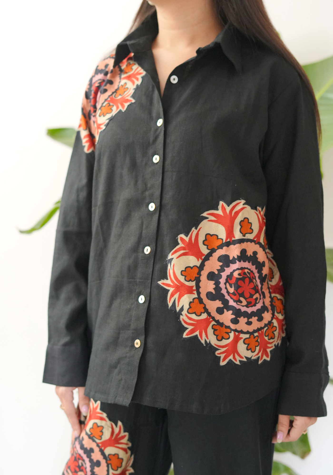 Black shirt with colorful floral patterns on the front and back.