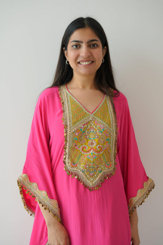 Woman wearing a pink and gold traditional outfit with a white background