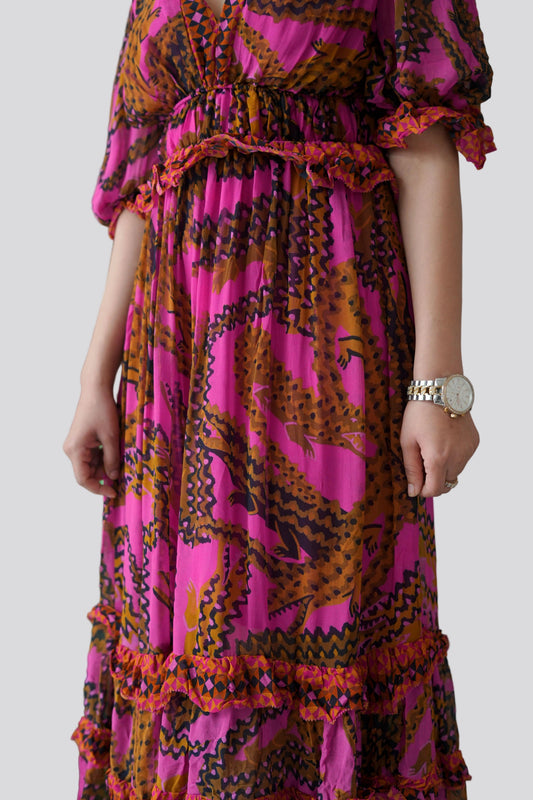 Close-up of a person wearing a vibrant, patterned dress with a plain background
