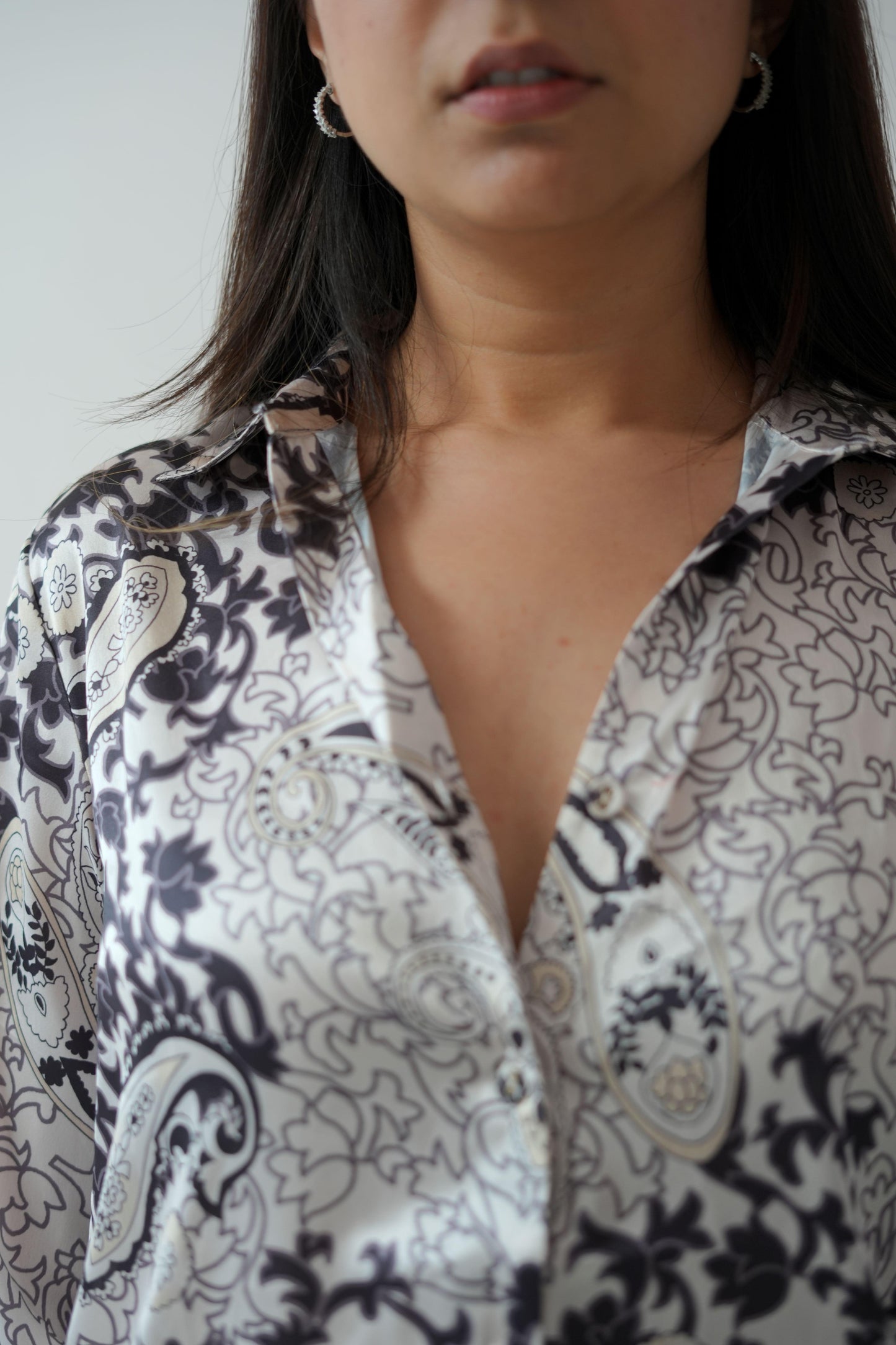 Woman wearing a patterned shirt with a blurred background