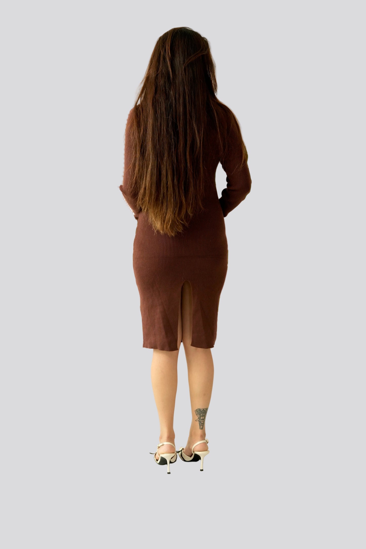 Person wearing a brown dress on a plain background