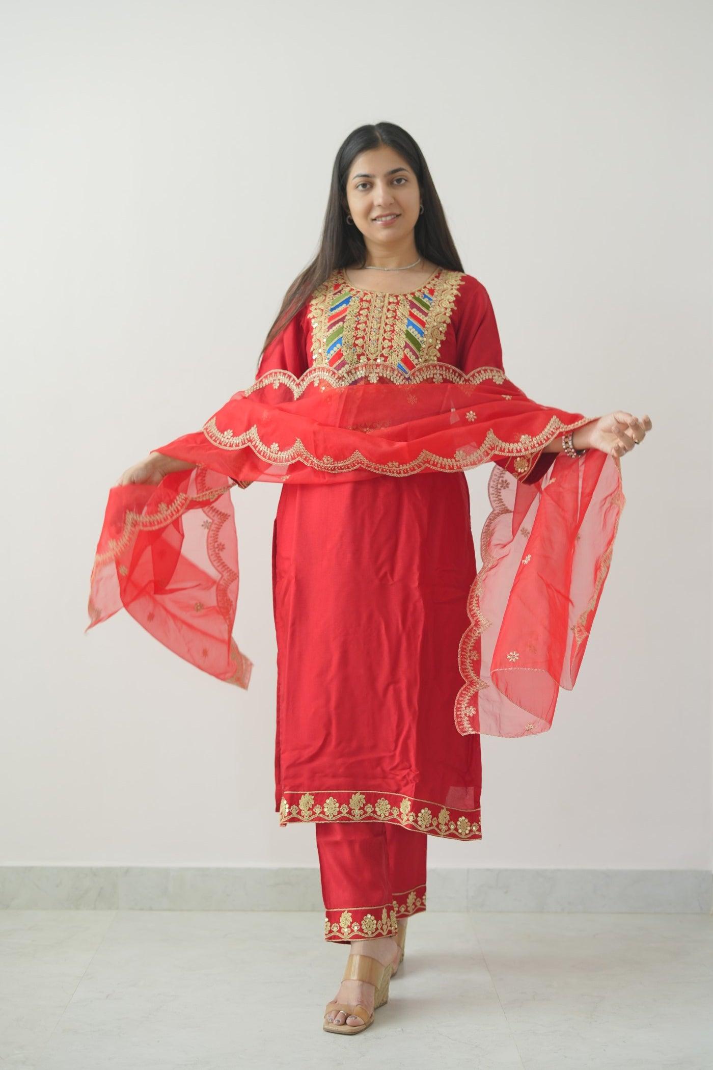 Woman wearing a red traditional outfit with gold embroidery on a white background