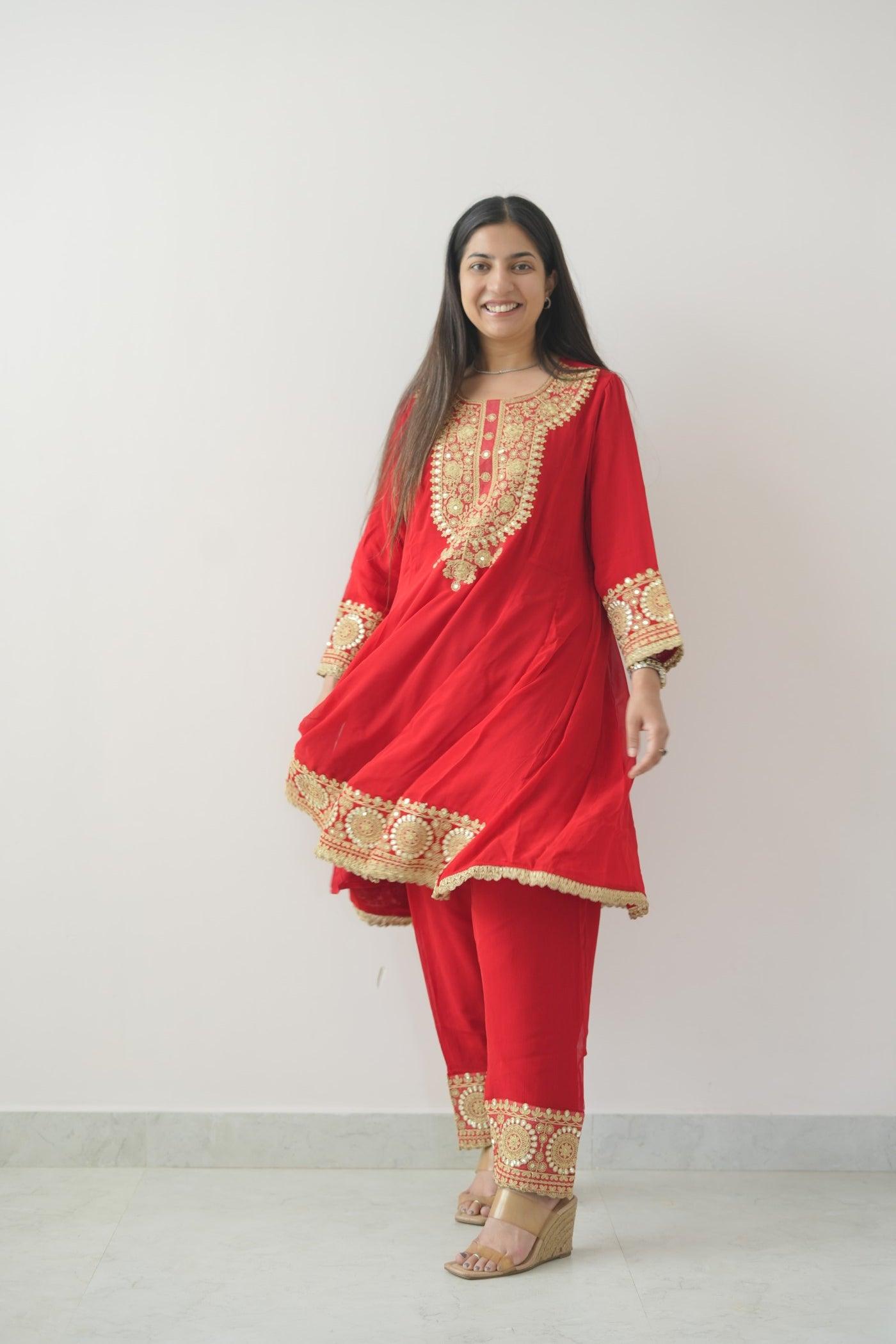 Woman wearing a red traditional outfit with gold embroidery on a white background