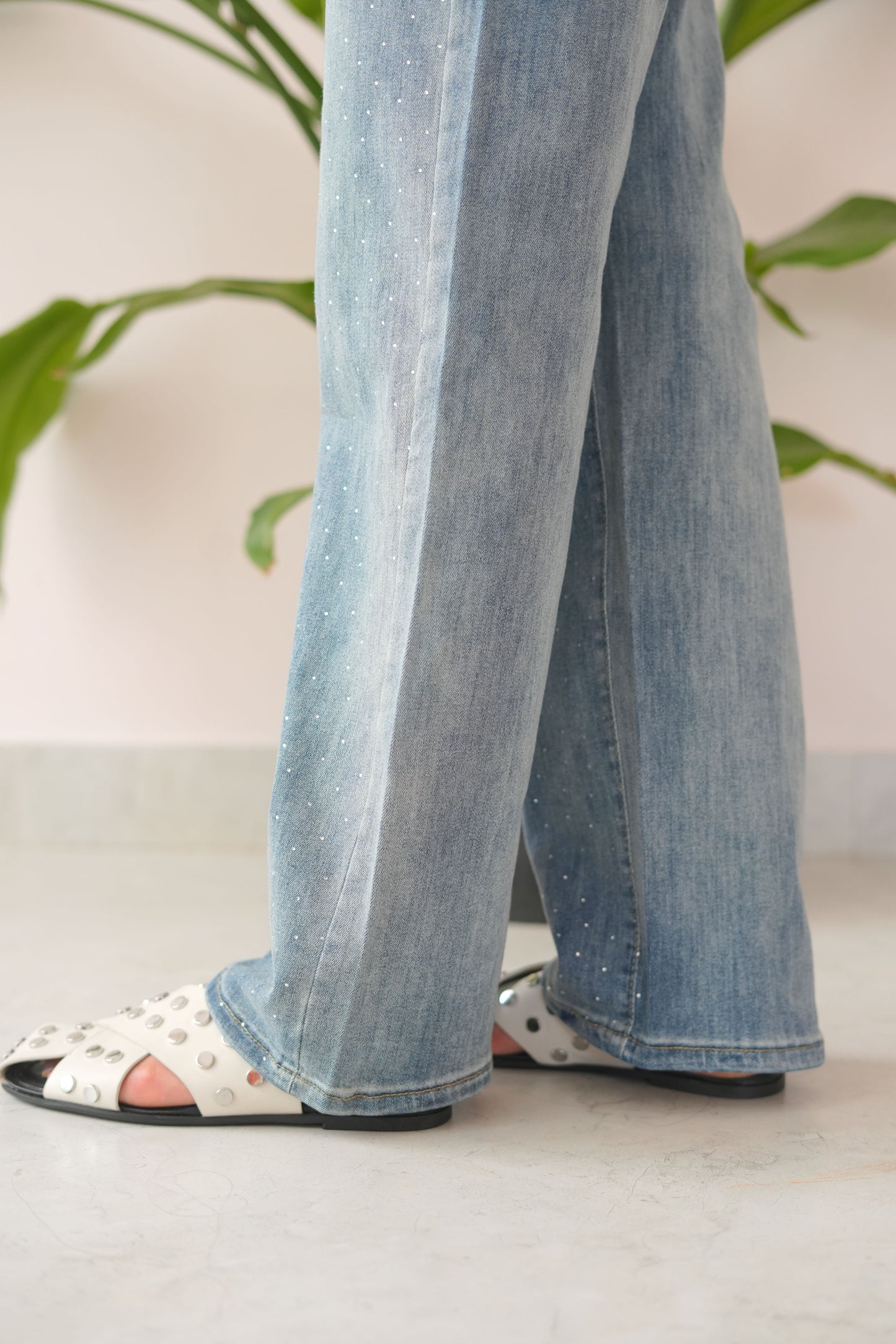 Close-up of light blue jeans being worn with a blurred background