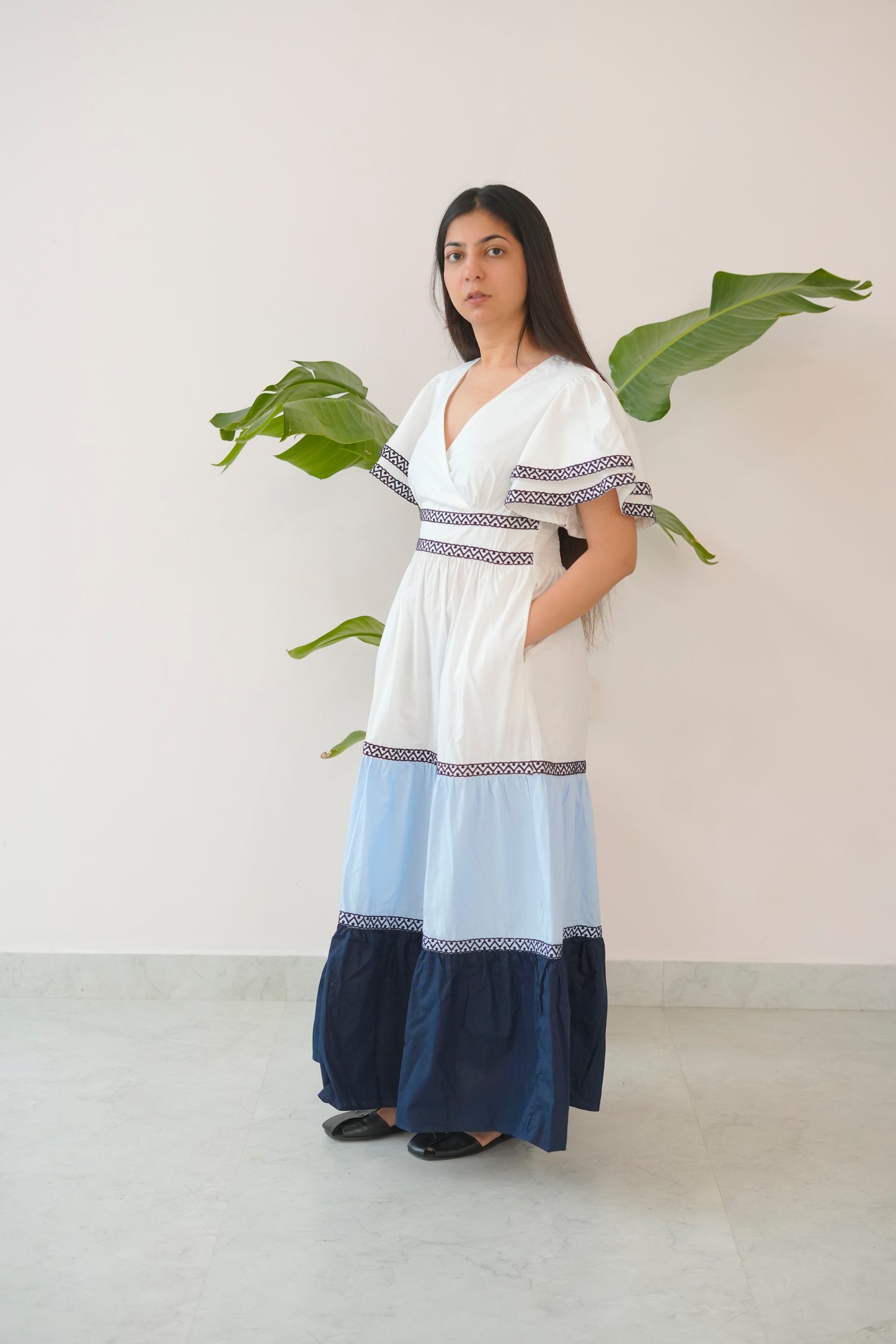 Woman wearing a white and blue dress with a plain background