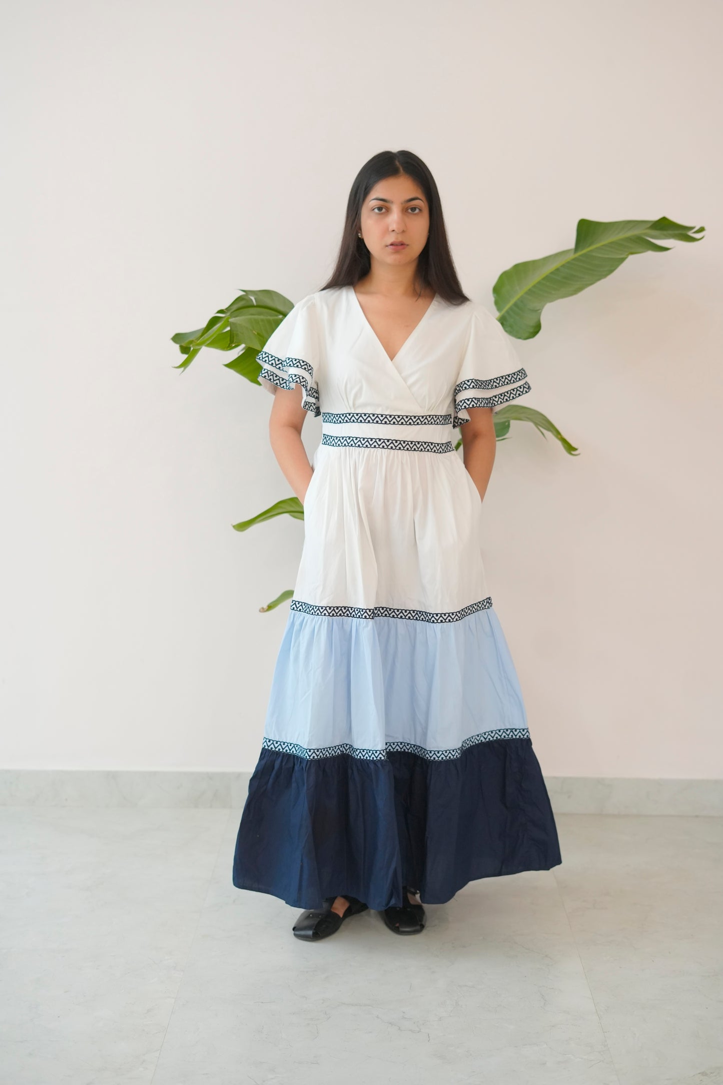 Woman wearing a white and blue dress with a plain background