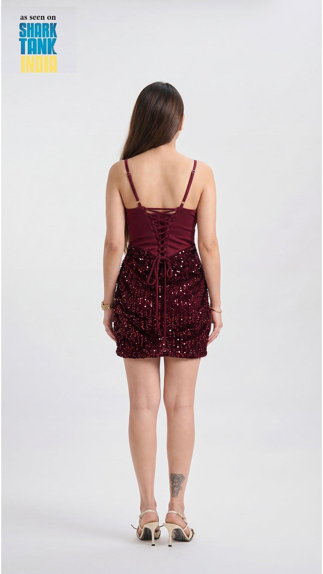 Woman wearing a burgundy sequin dress on a white background with 'Shark Tank' branding.