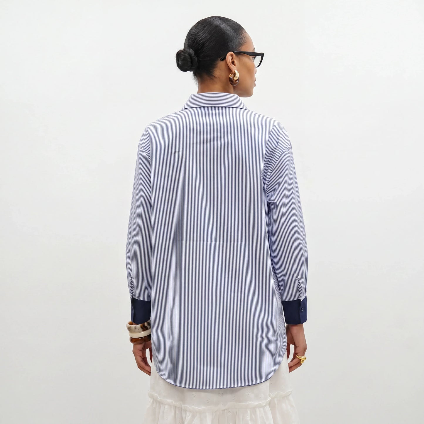 Person wearing a blue and white striped shirt against a white background