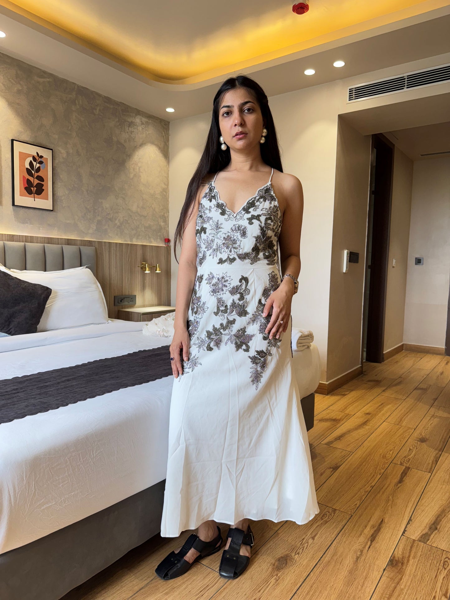Woman in a floral dress standing in a bedroom