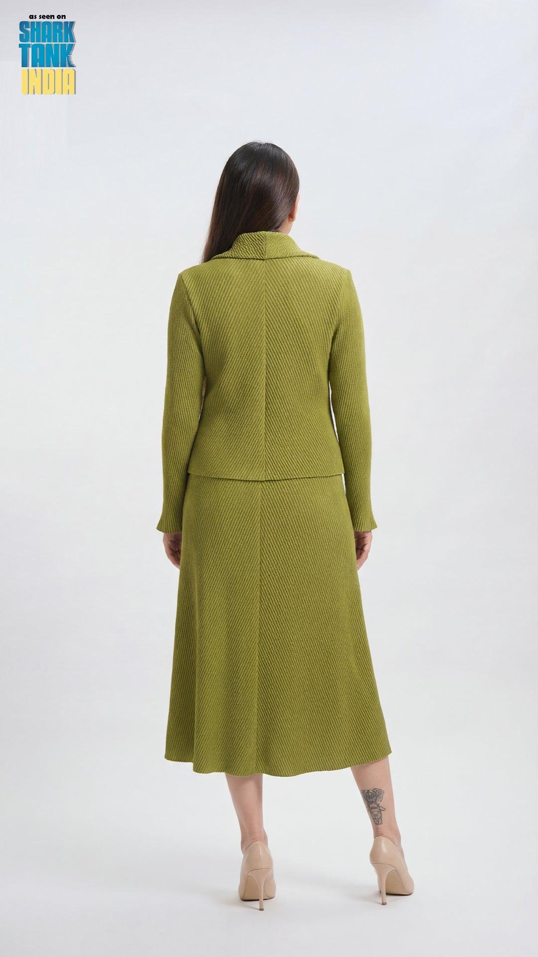 Woman wearing a green suit standing against a white background