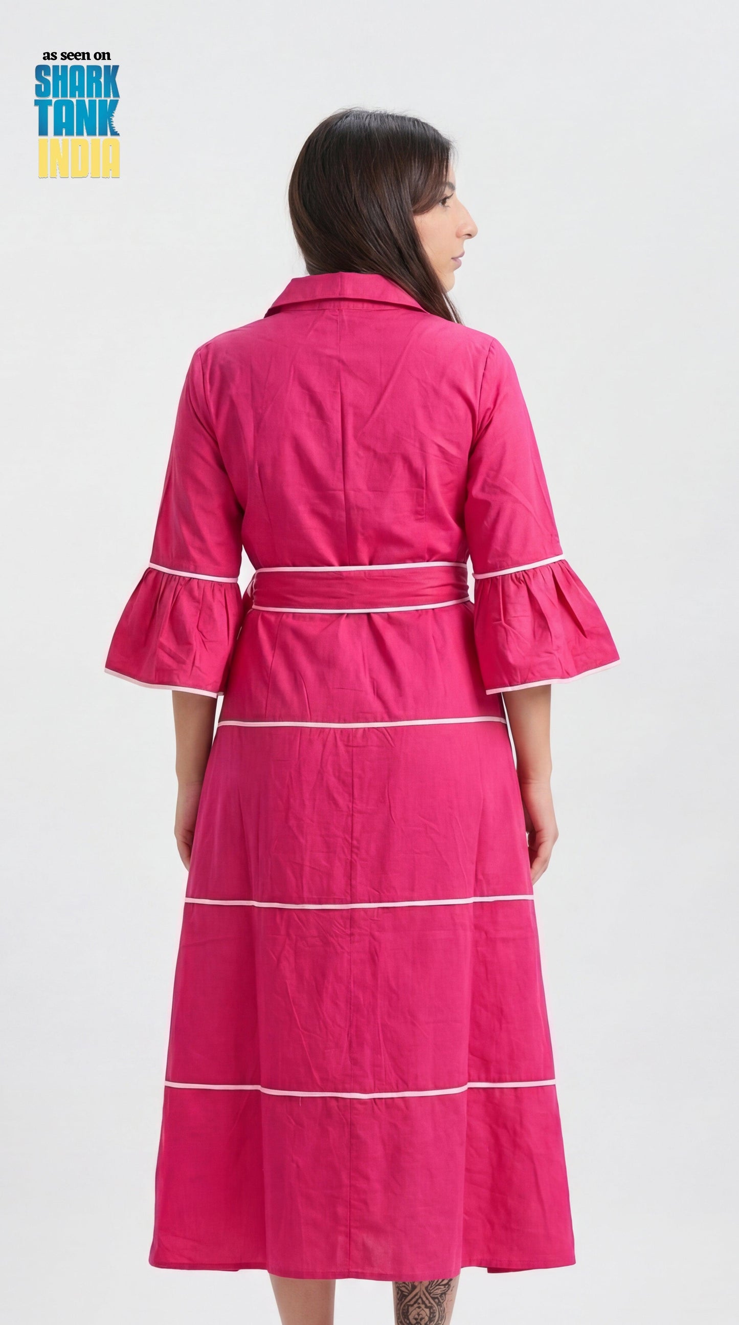 Woman wearing a pink dress with white stripes on a white background