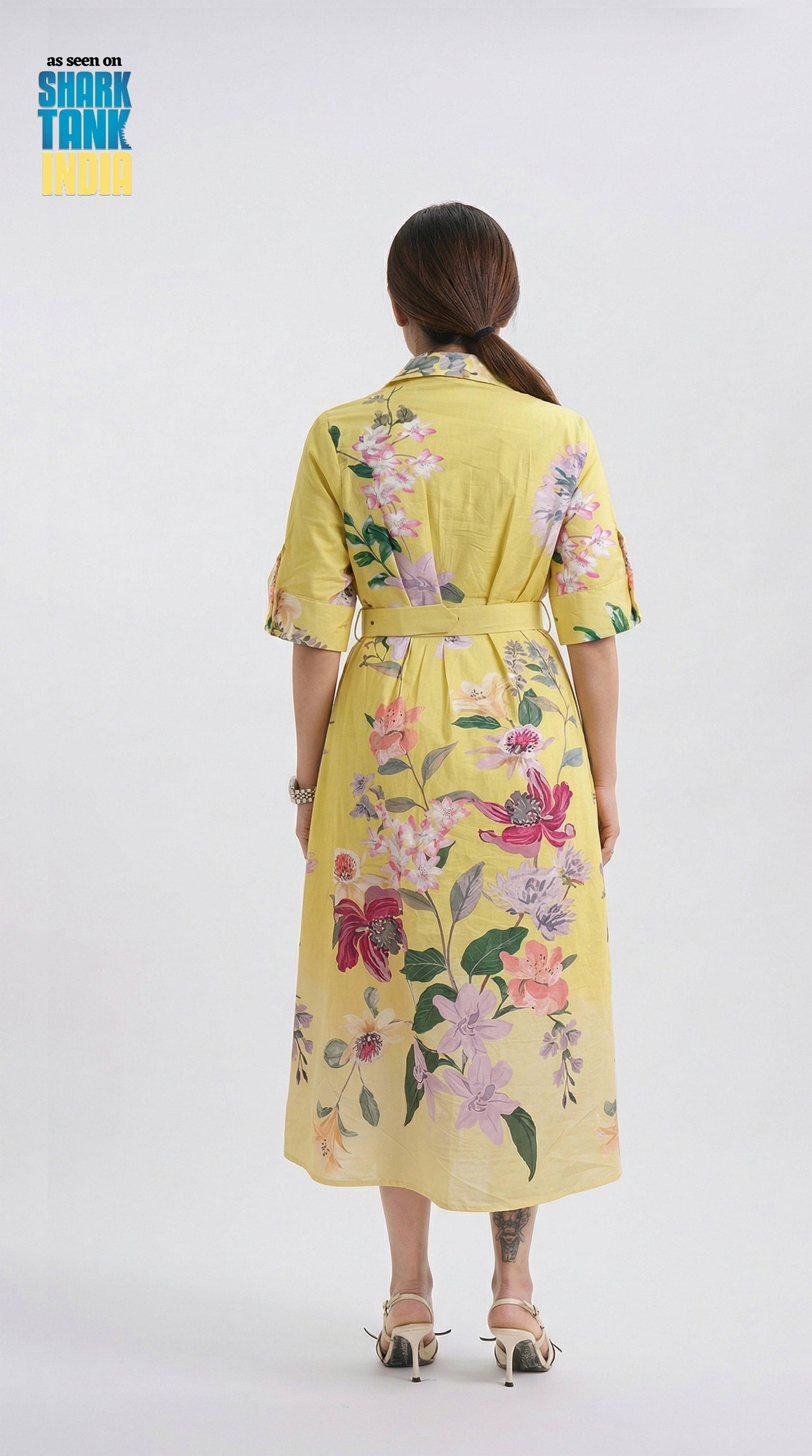 Woman wearing a yellow floral dress on a white background with 'Shark Tank' branding.