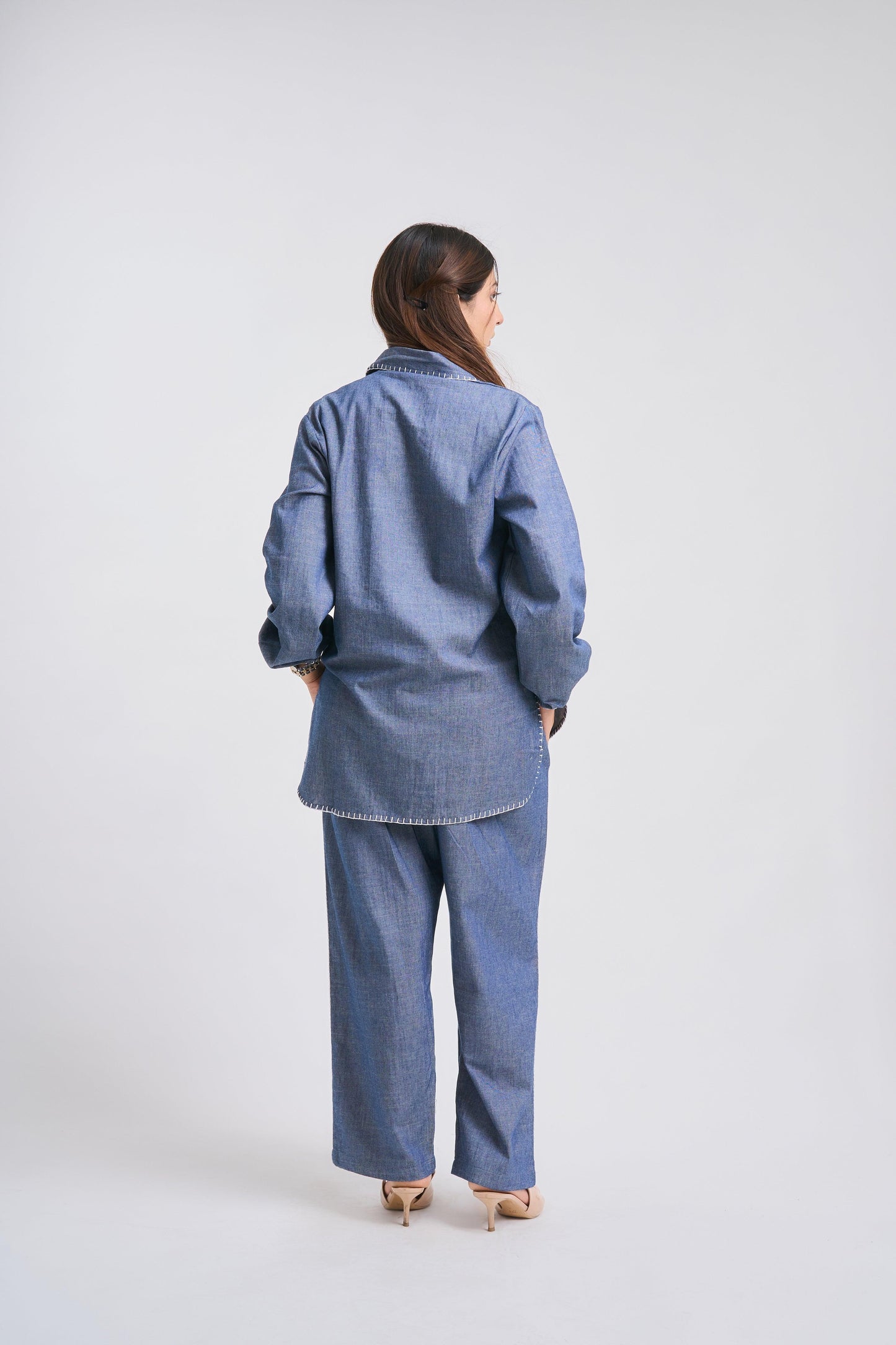 Person wearing a blue denim outfit on a white background