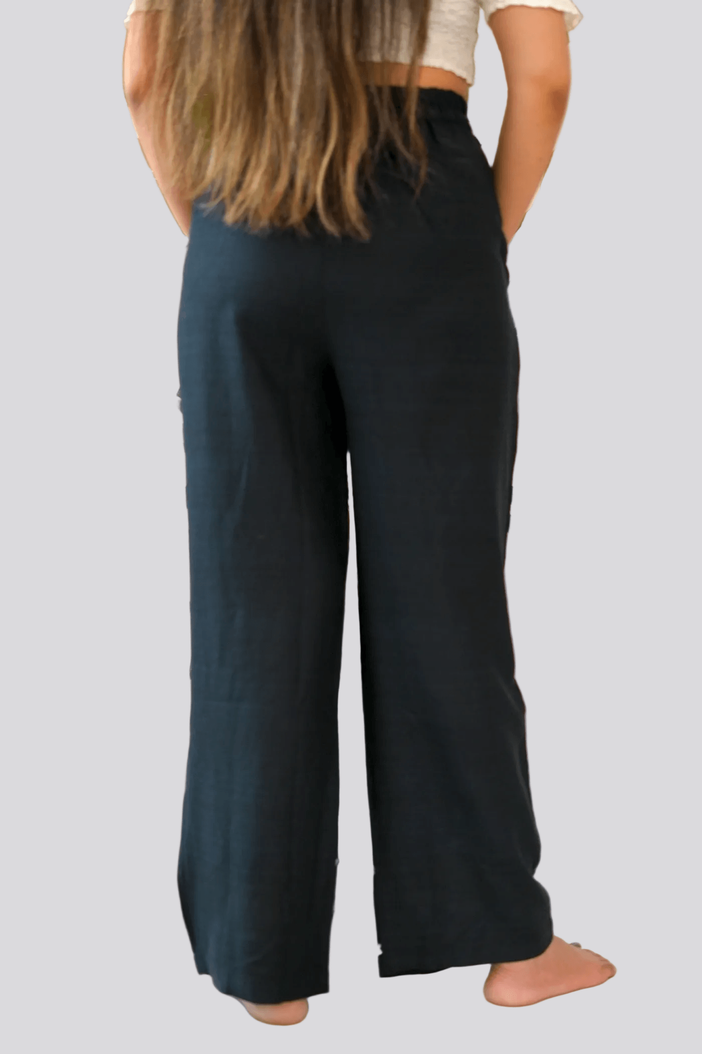 Person wearing dark blue pants on a plain background