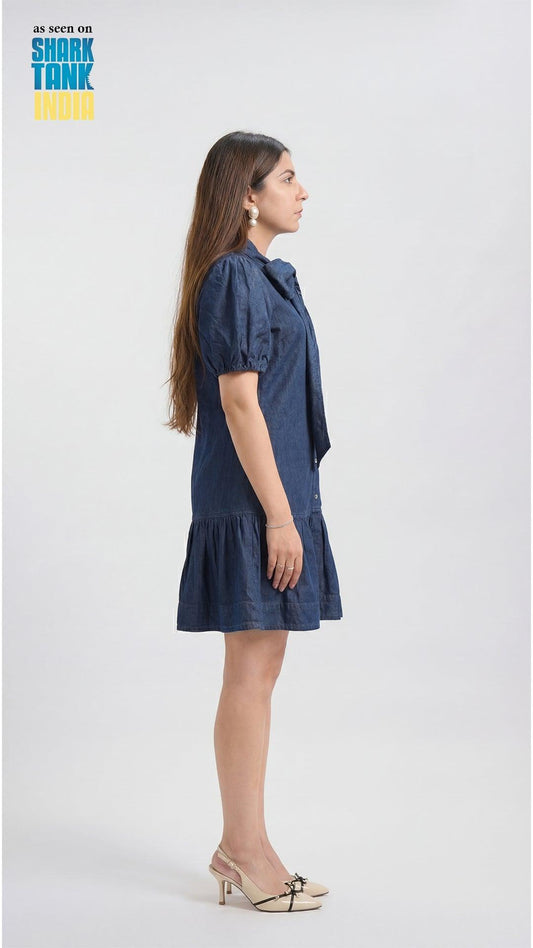 Woman wearing a blue dress on a white background with 'Shark Tank' branding.