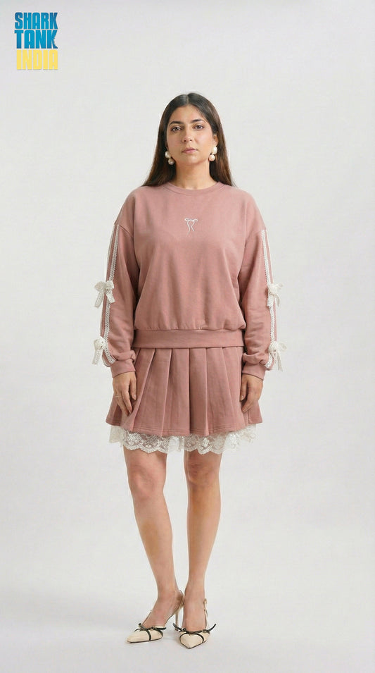 Woman wearing a pink outfit with lace details on a white background