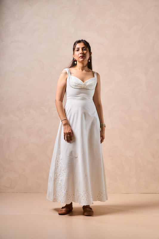 Woman wearing a white dress against a beige background