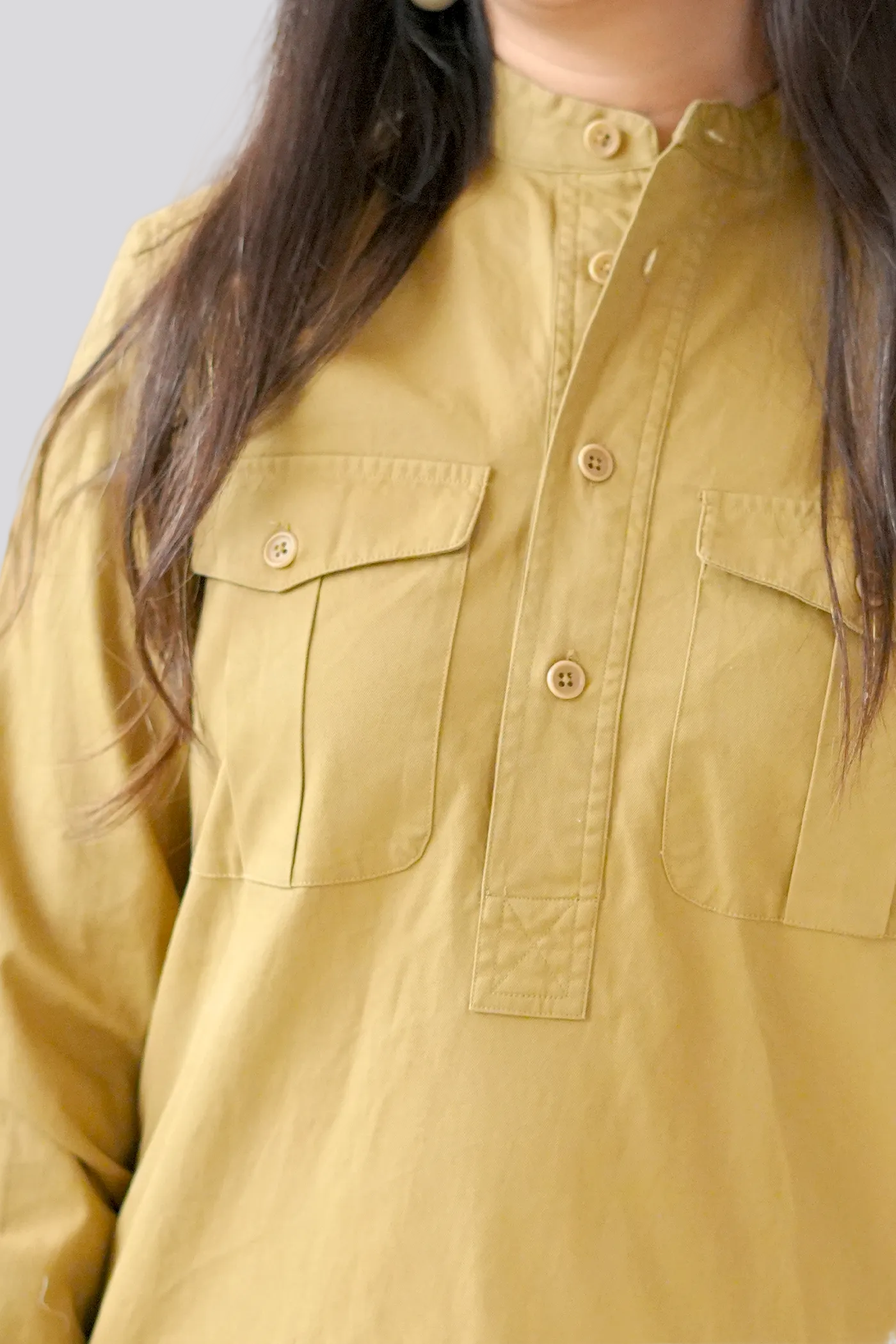 Close-up of a mustard yellow shirt with button details