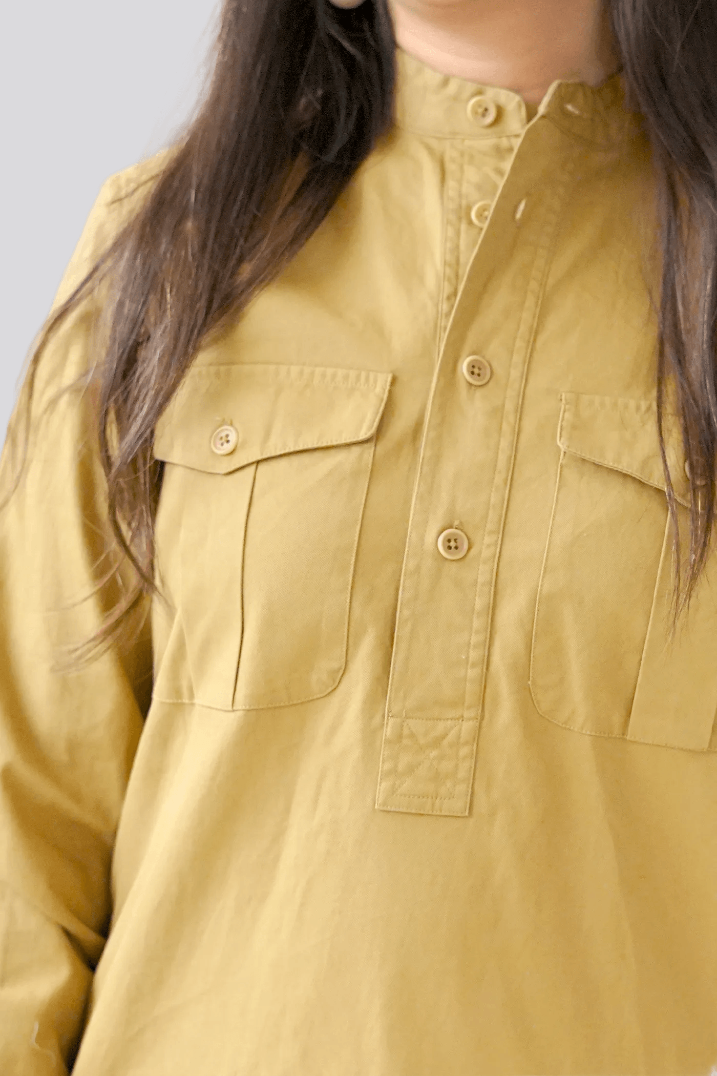 Close-up of a mustard yellow shirt with button details
