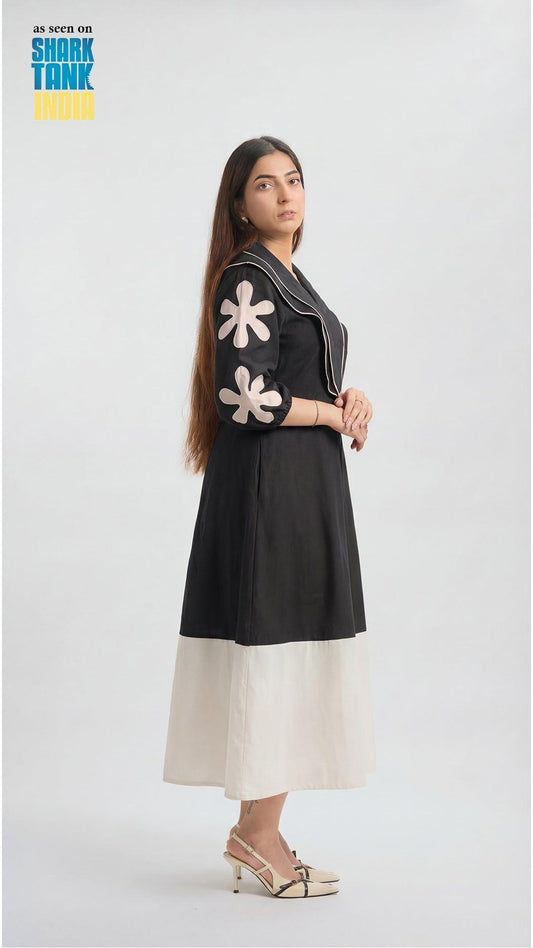 Woman wearing a black dress with white floral patterns on a white background
