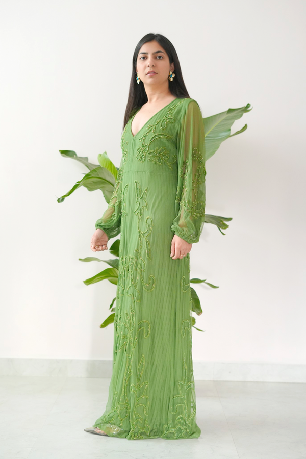 Woman wearing a green lace dress standing against a white background