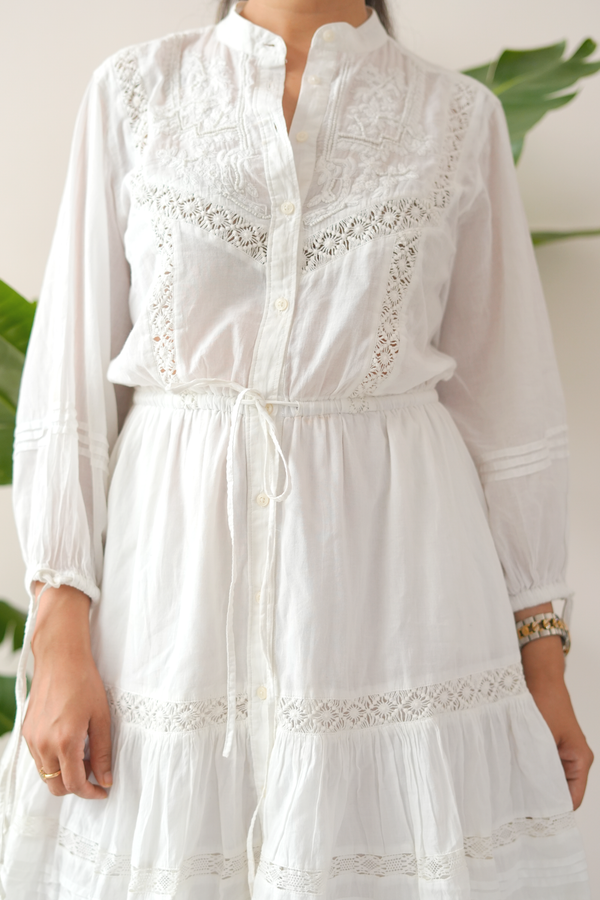 White dress with intricate lace details on a neutral background