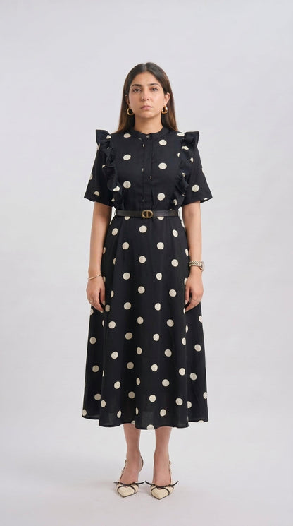 Woman wearing a black dress with white polka dots on a white background