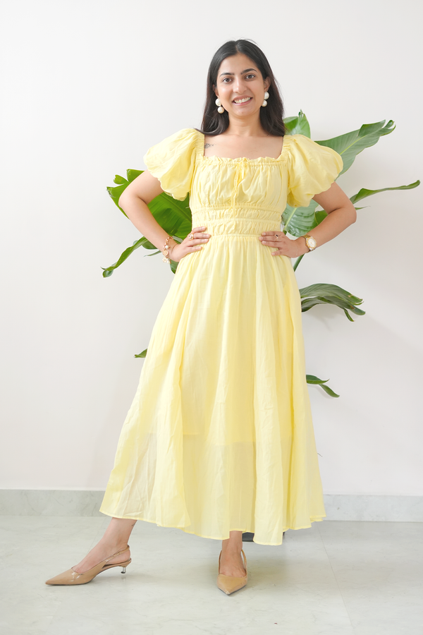 Woman wearing a yellow dress with leafy background