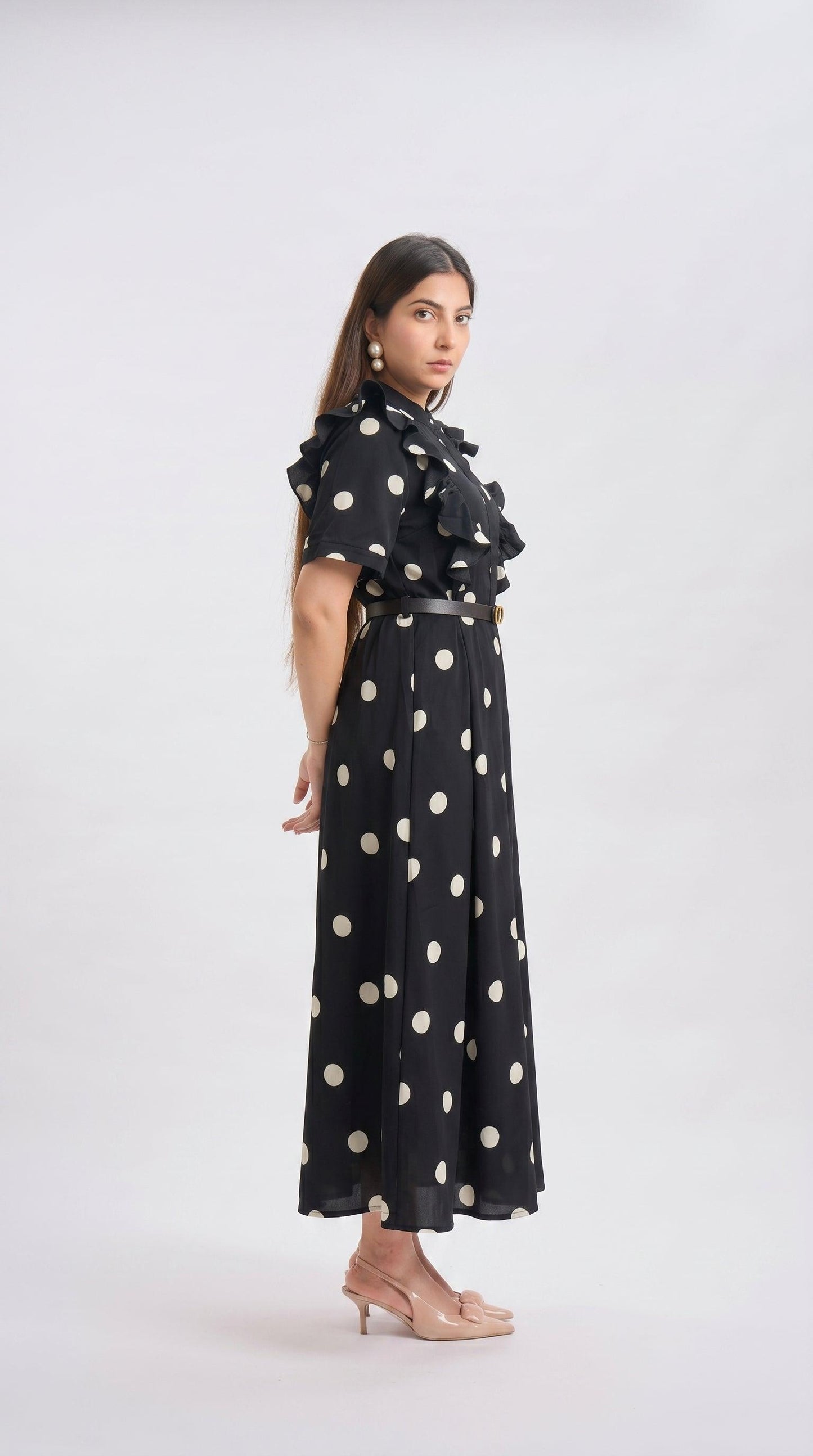 Woman wearing a black dress with white polka dots on a white background