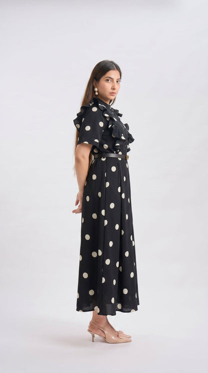Woman wearing a black dress with white polka dots on a white background