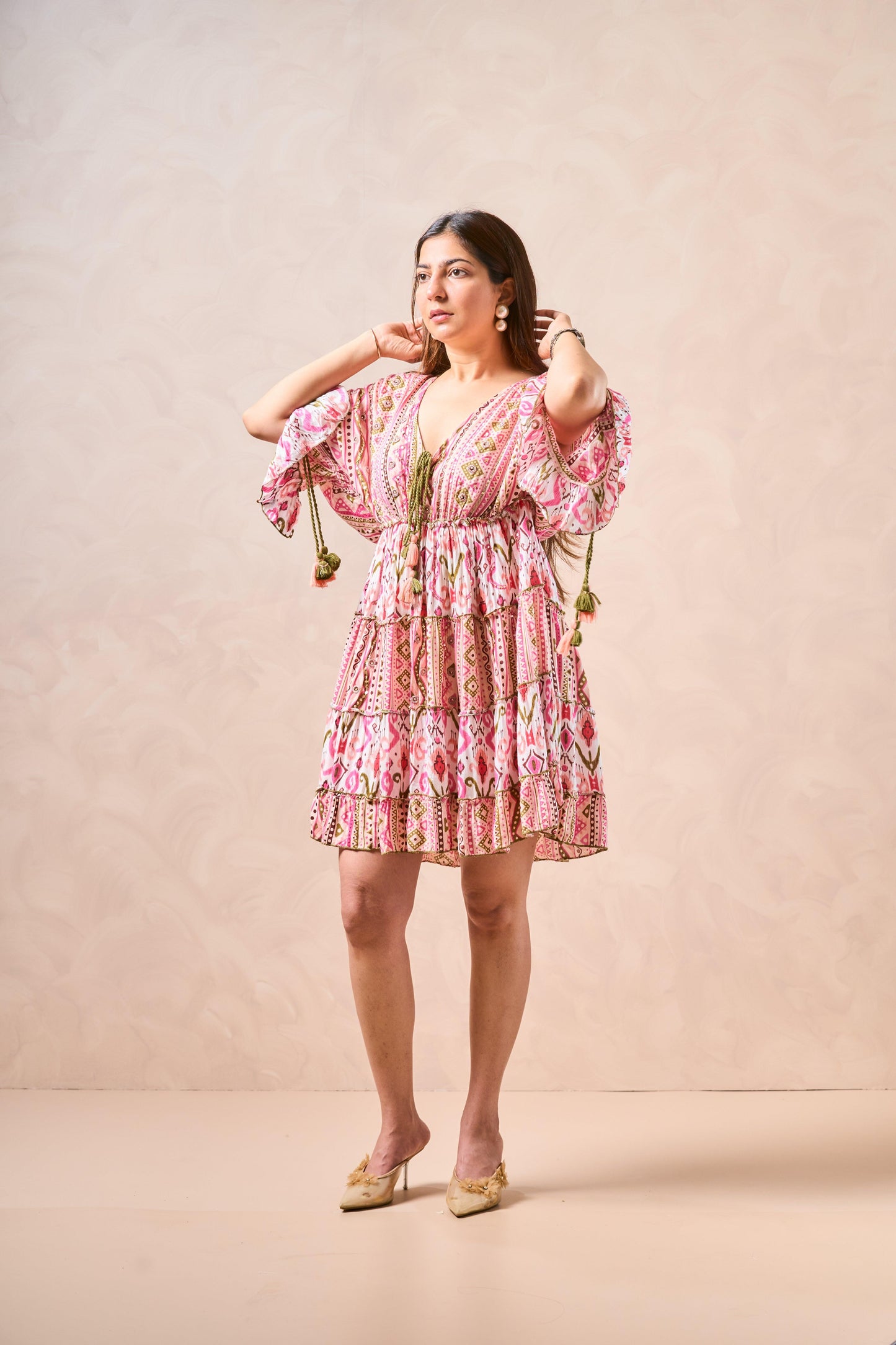 Woman wearing a pink floral dress against a beige background