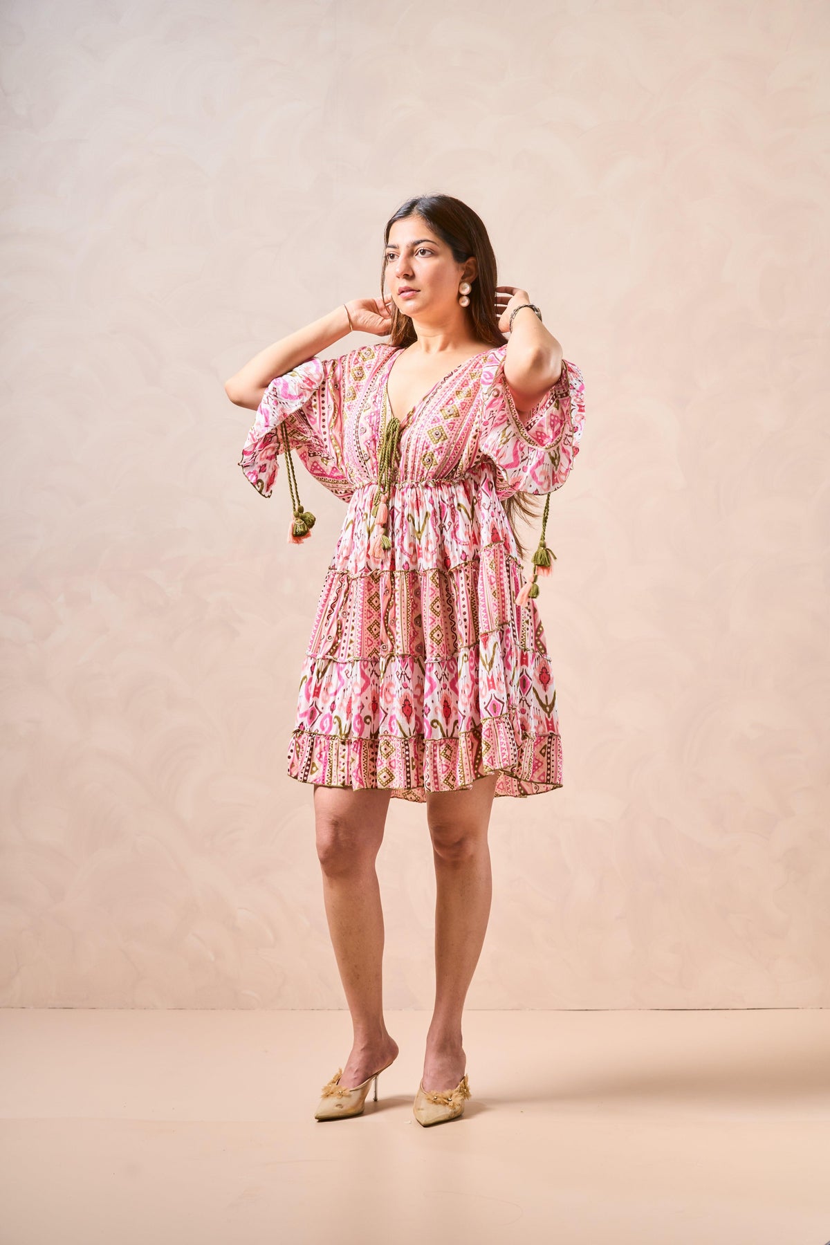 Woman wearing a pink floral dress against a beige background