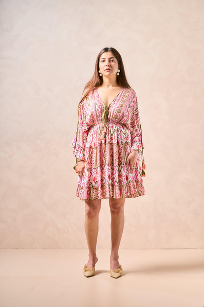 Woman wearing a pink patterned dress against a beige background