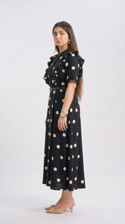 Woman wearing a black dress with white polka dots on a white background