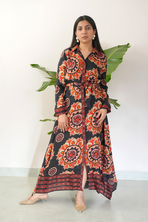 Woman wearing a long, patterned dress with a white background