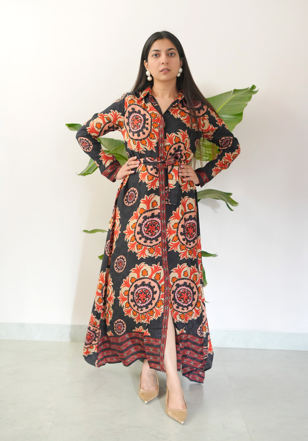 Woman wearing a patterned dress with large leaves in the background