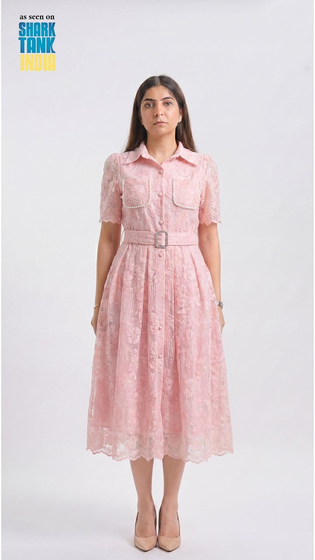 Woman wearing a pink dress with a belt on a white background