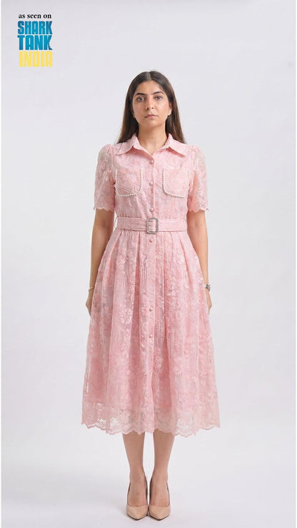Woman wearing a pink dress with a belt on a white background