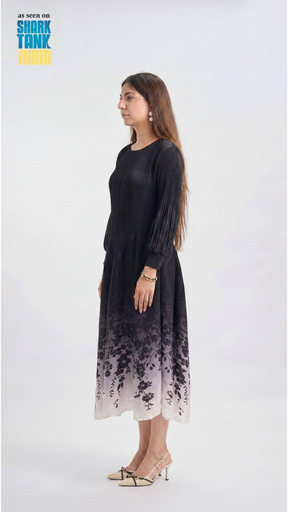 Woman wearing a black dress with floral pattern on a white background