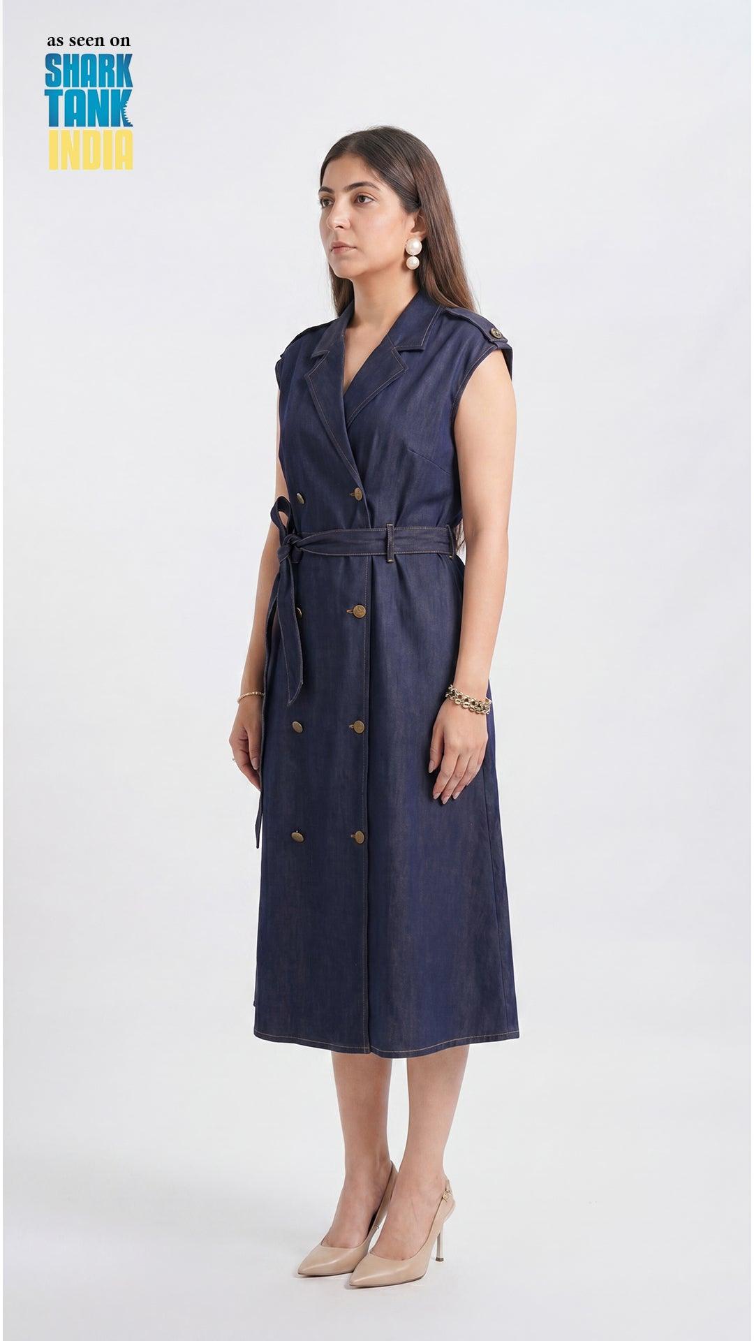 Woman wearing a navy blue sleeveless dress with buttons on a white background