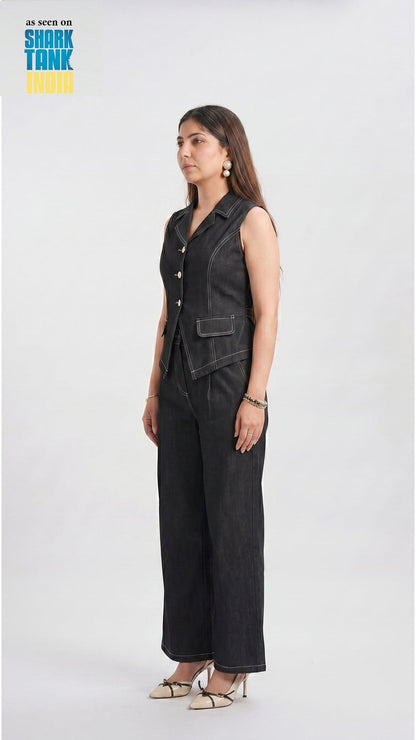 Woman wearing a black denim vest and wide-leg pants on a white background