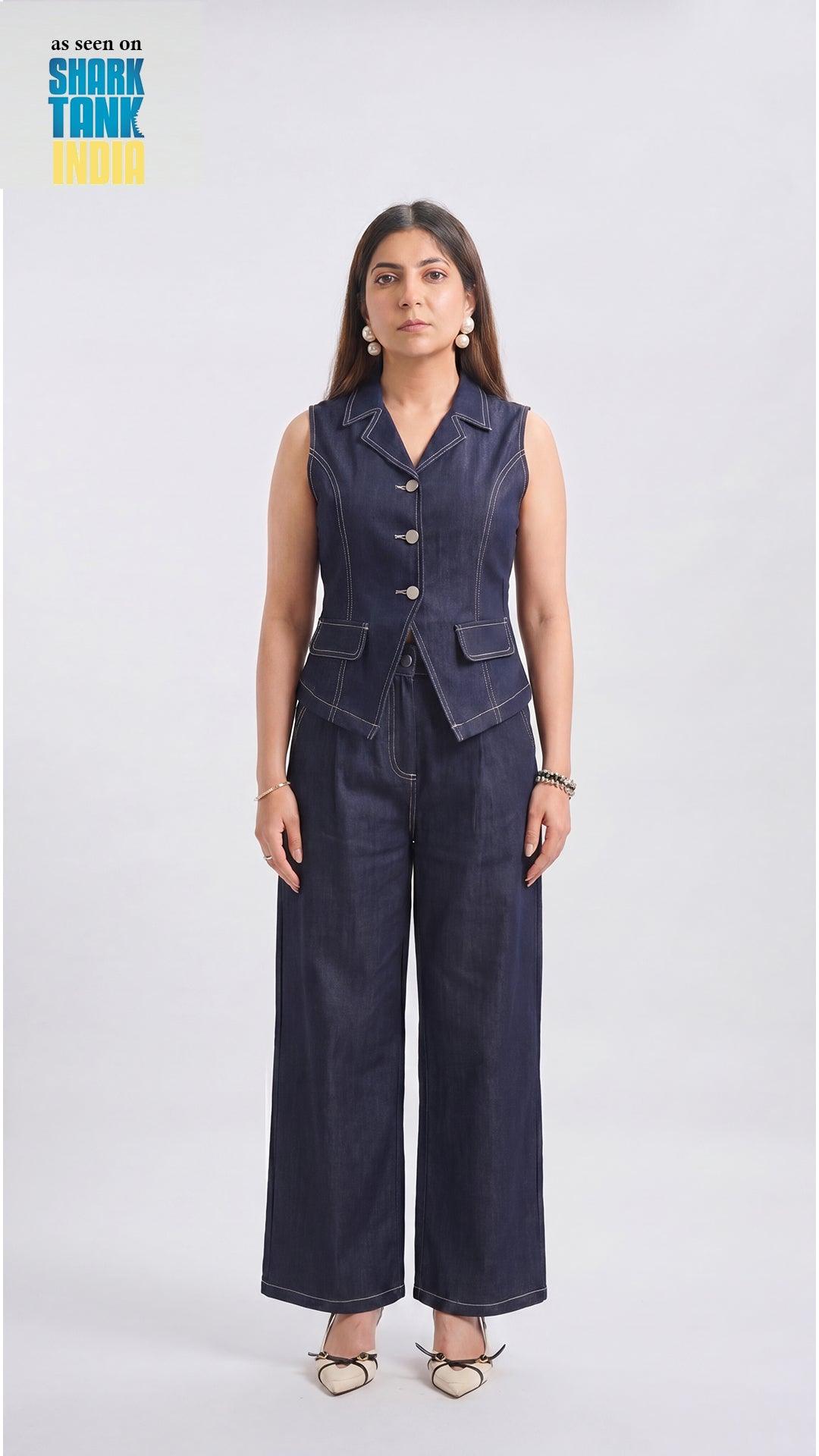 Woman wearing a navy blue sleeveless blazer and wide-leg pants on a white background
