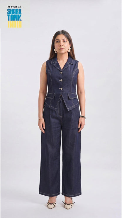 Woman wearing a navy blue sleeveless blazer and wide-leg pants on a white background