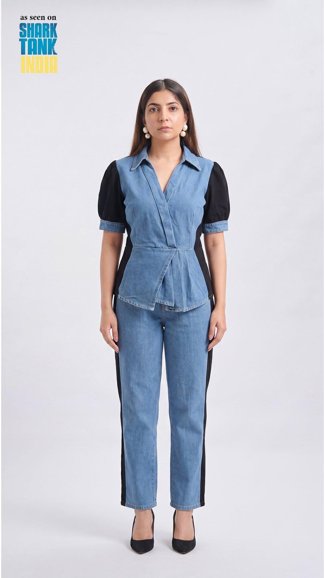 Woman wearing a denim jumpsuit with a black top on a white background