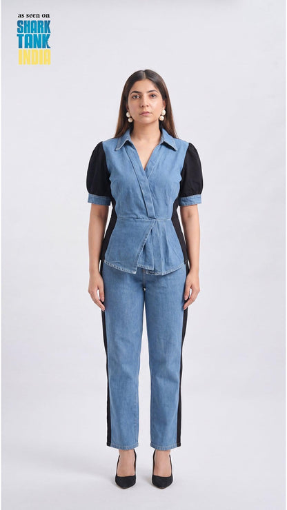 Woman wearing a denim jumpsuit with a black top on a white background