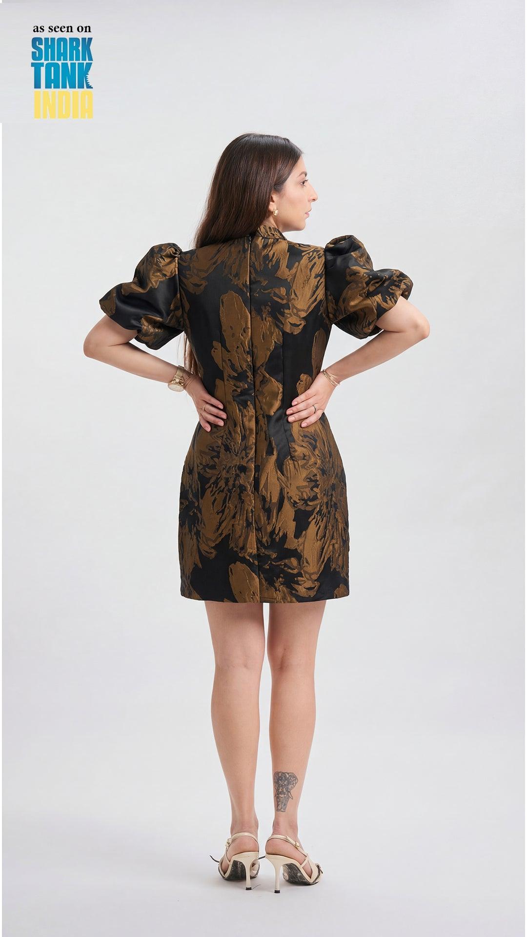 Woman wearing a patterned dress with puffed sleeves on a white background, Shark Tank logo visible.
