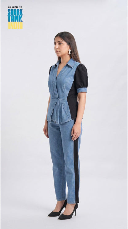 Woman wearing a denim and black jumpsuit on a white background