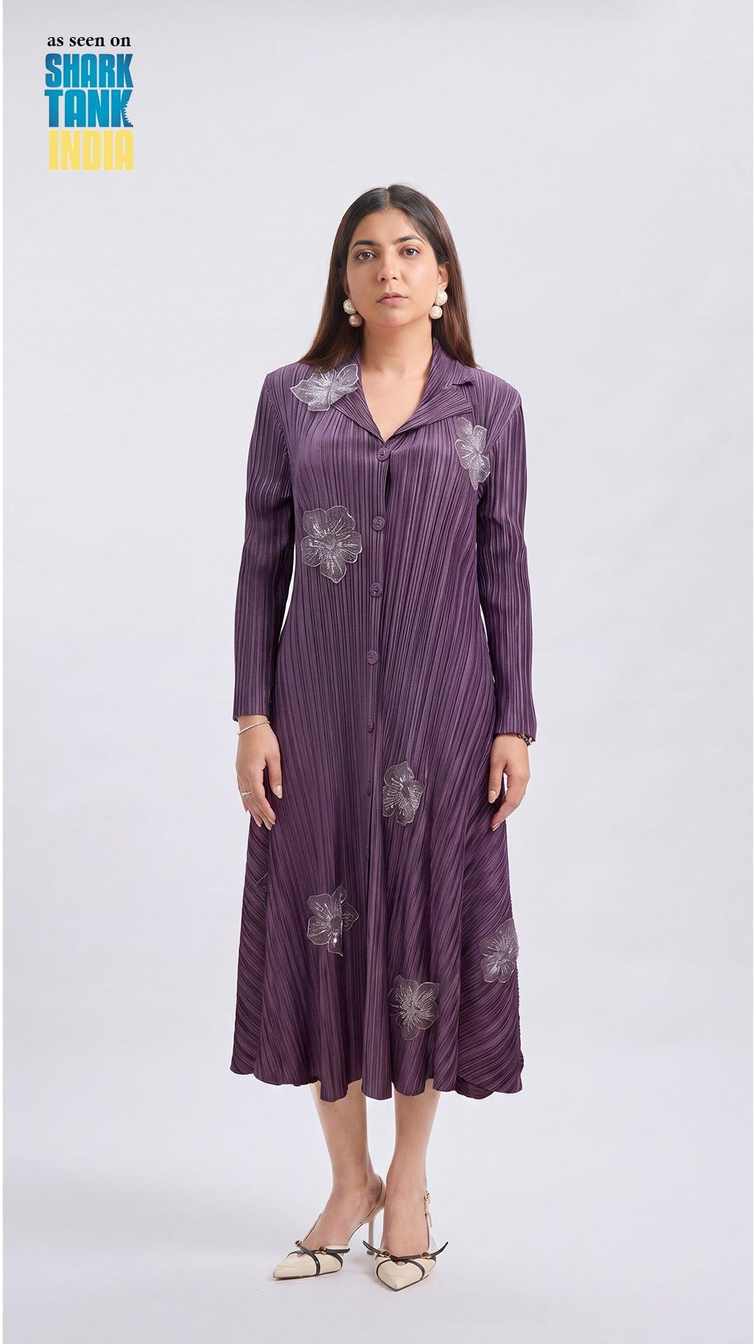 Woman wearing a purple dress with floral patterns on a white background