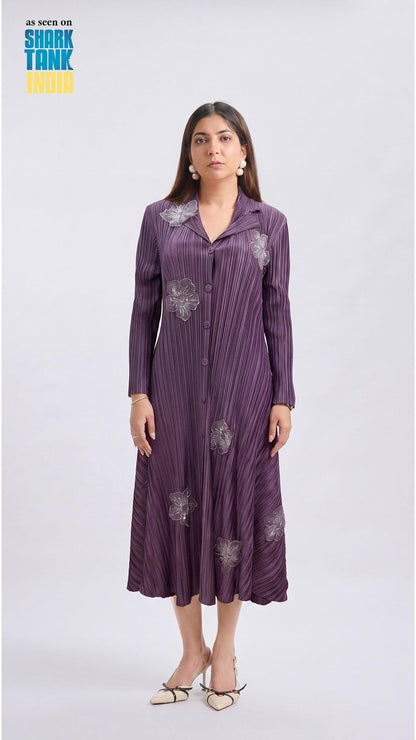 Woman wearing a purple dress with floral patterns on a white background